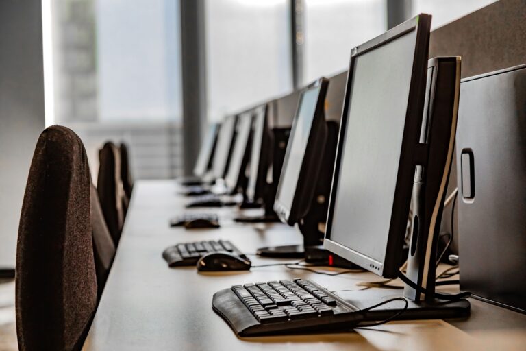 Row of computer workstations in an office with natural light coming through the windows